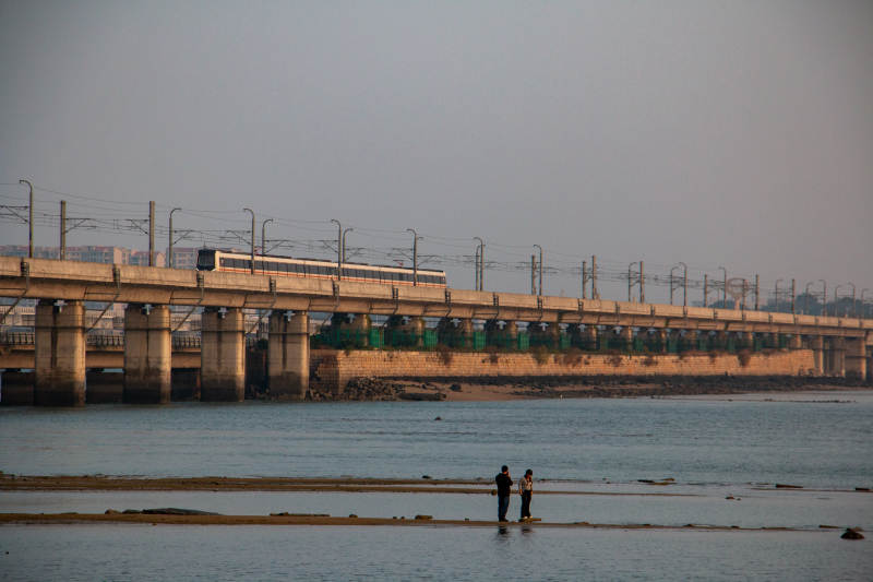 厦门桥上列车 水边行人 海上列车图片