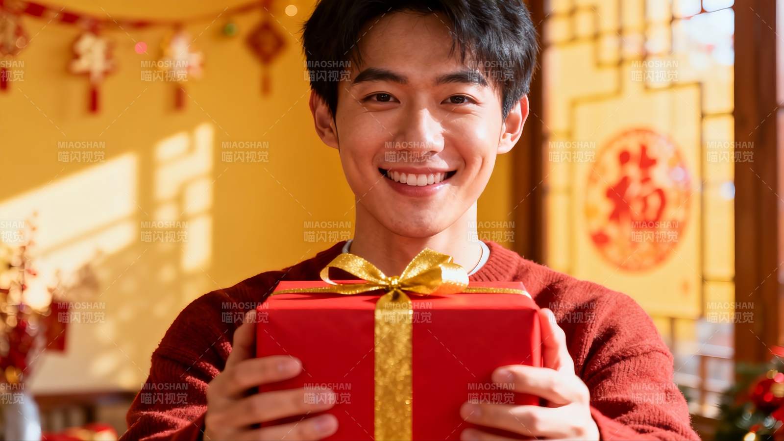 青年男子手持红色礼盒笑容满面图片