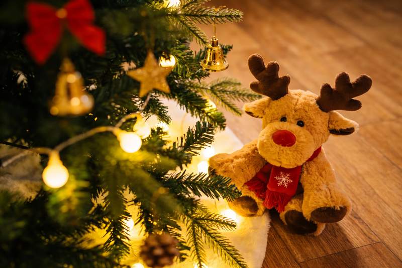 圣诞树旁的驯鹿玩偶温馨场景图片