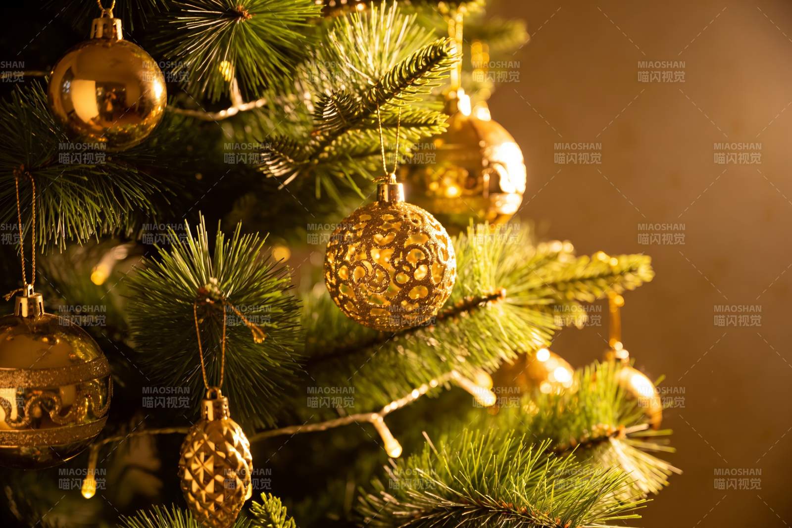 金色圣诞球装饰的节日松枝图片