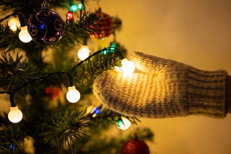 圣诞树前的手戴手套图片