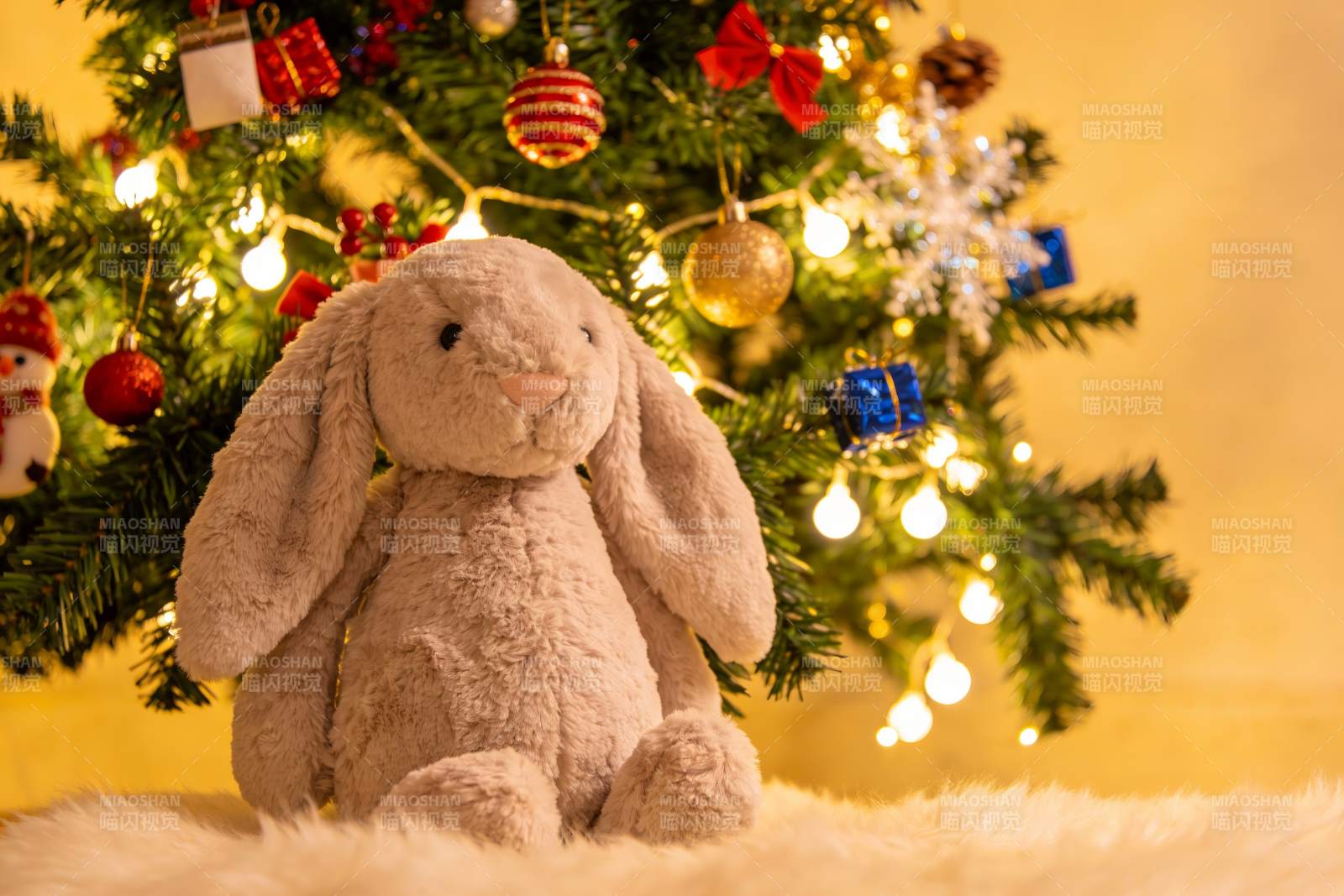 圣诞树前的毛绒兔子玩偶图片
