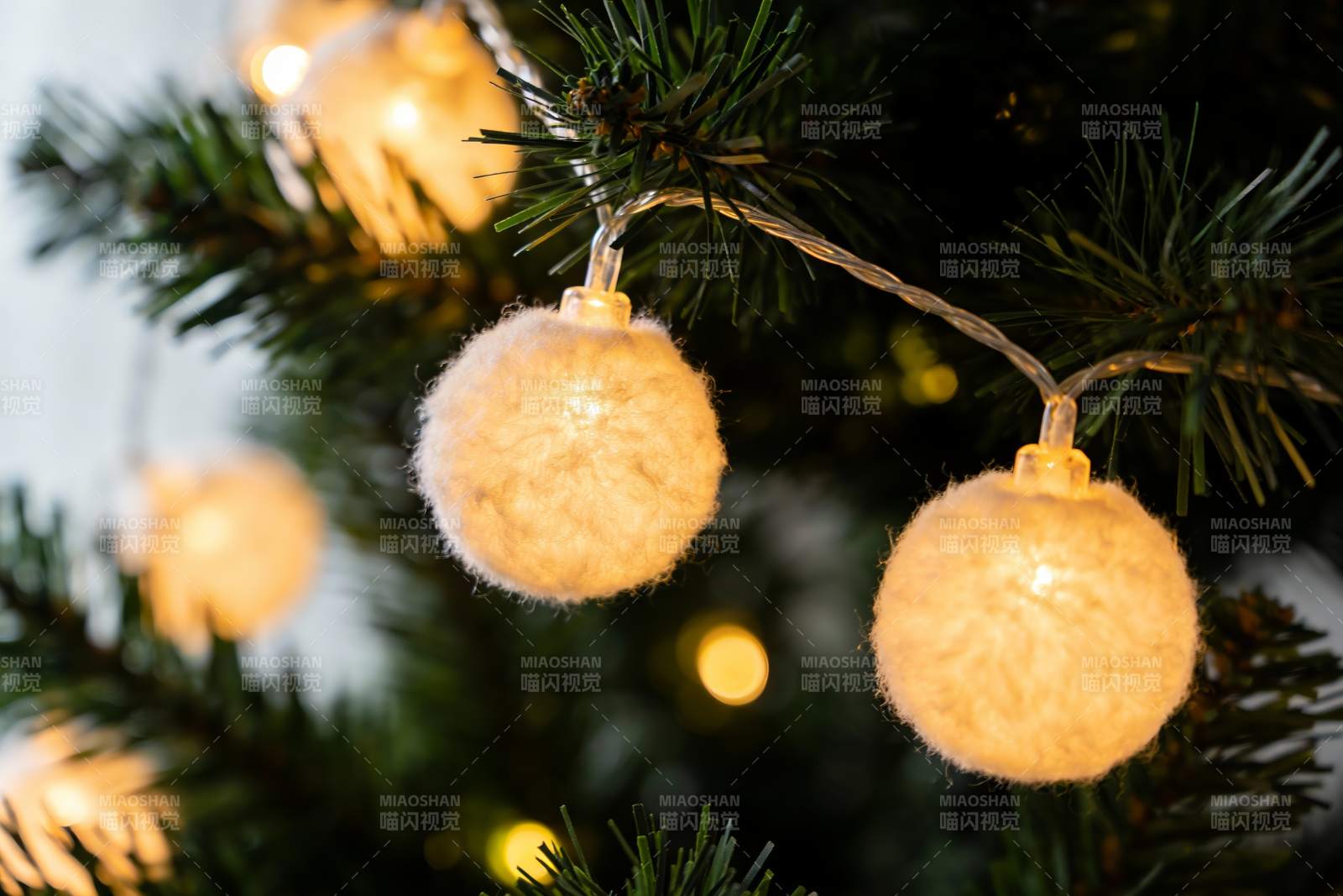 圣诞树上的毛绒灯串特写图片