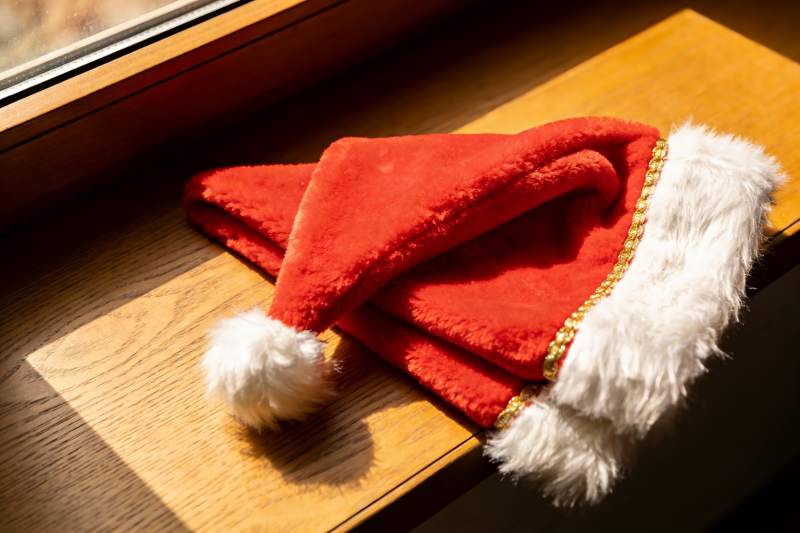 圣诞帽置于窗边木质台面图片