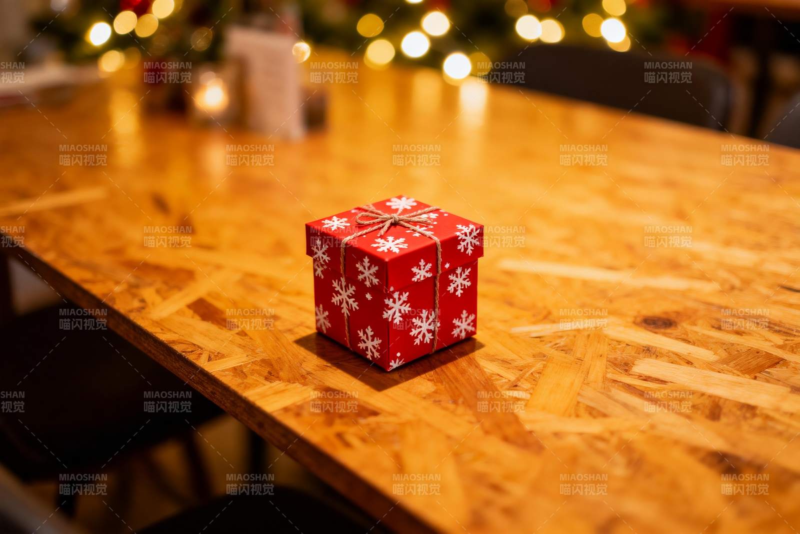 红色雪花礼盒置于木质桌面图片