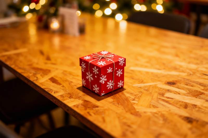 红色雪花礼盒置于木质桌面图片