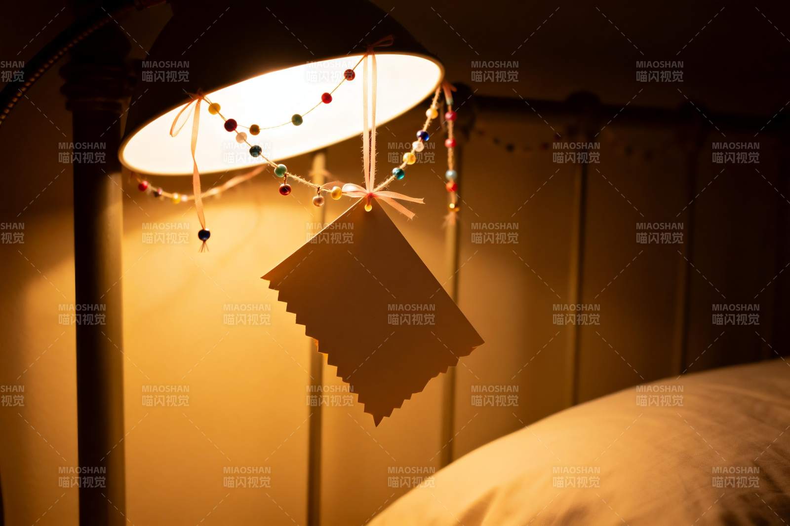 暖光灯下悬挂的卡片与装饰图片