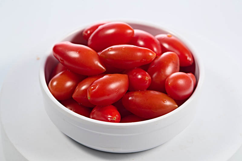 白色背景上摆放的鲜红圣女果图片