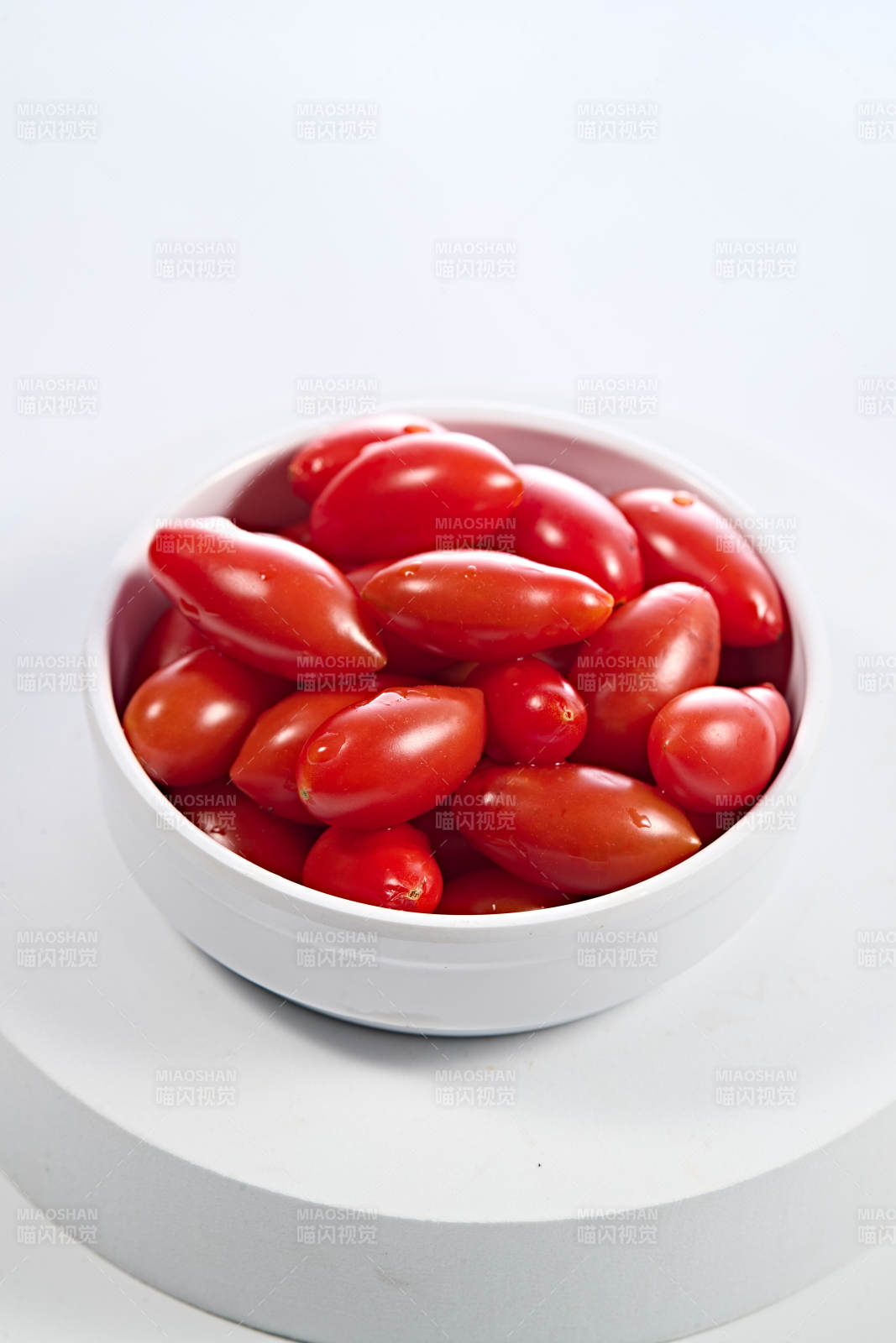 白色背景上摆放的鲜红圣女果图片