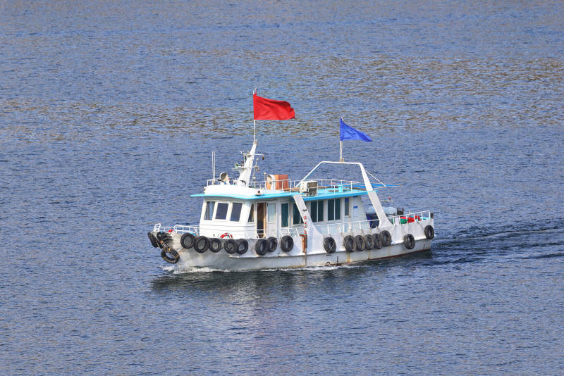 一艘游船在碧蓝的湖面上行驶图片