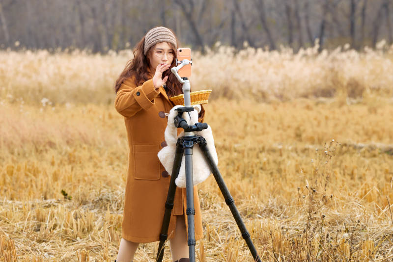 深秋季节在户外进行直播带货的亚洲女性图片
