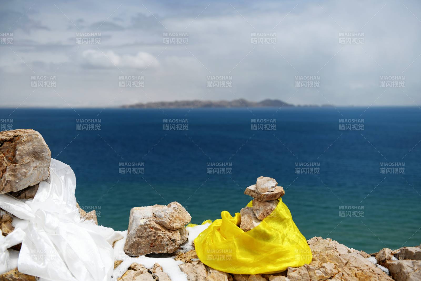 西藏海边石堆上的黄裙人偶图片