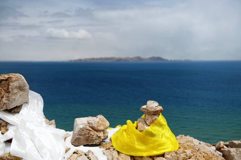 西藏海边石堆上的黄裙人偶图片