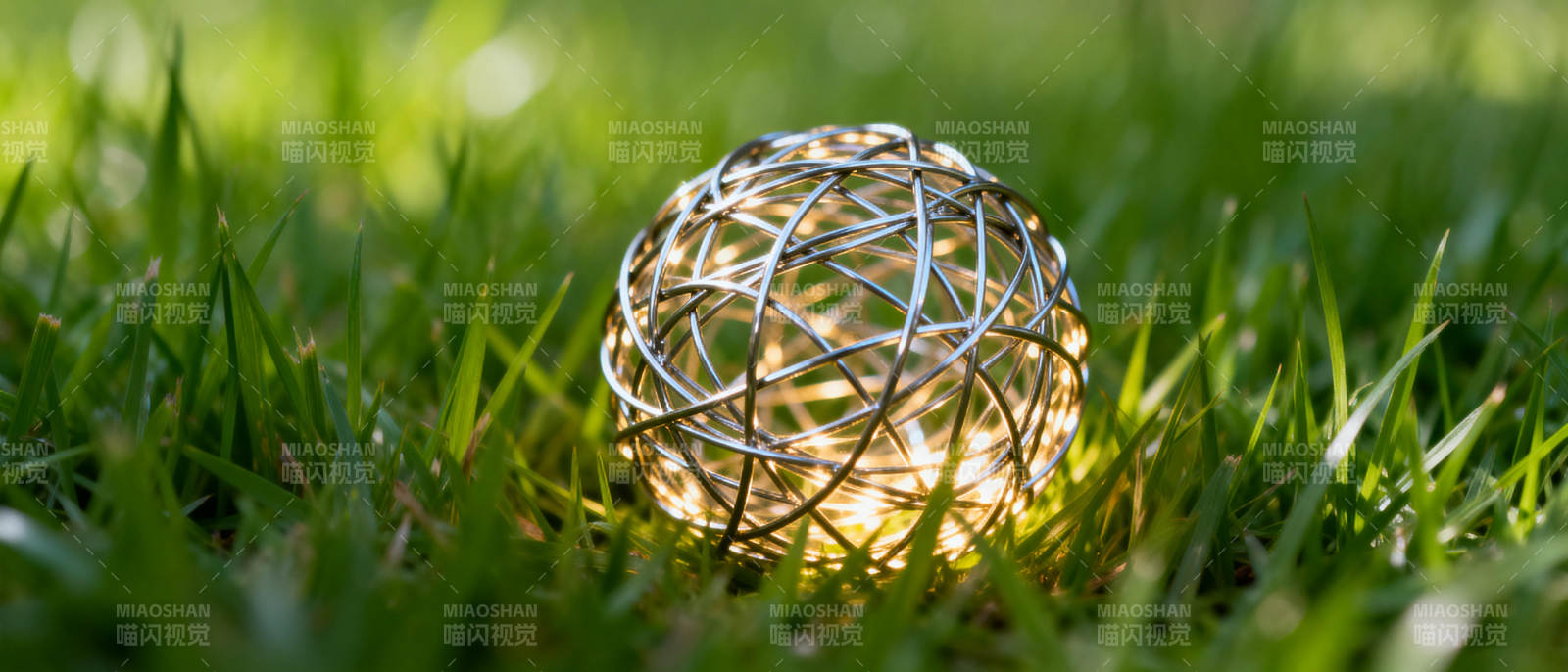 草地上发光的金属球图片