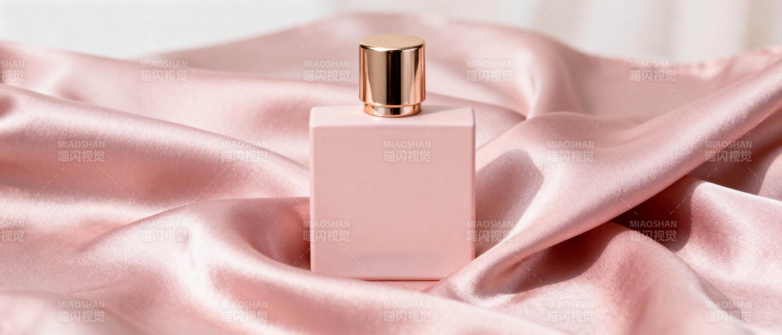 粉色香水瓶静置丝缎上图片