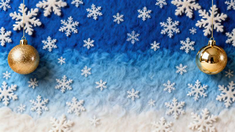 蓝色渐变背景上的金色圣诞球与雪花图片
