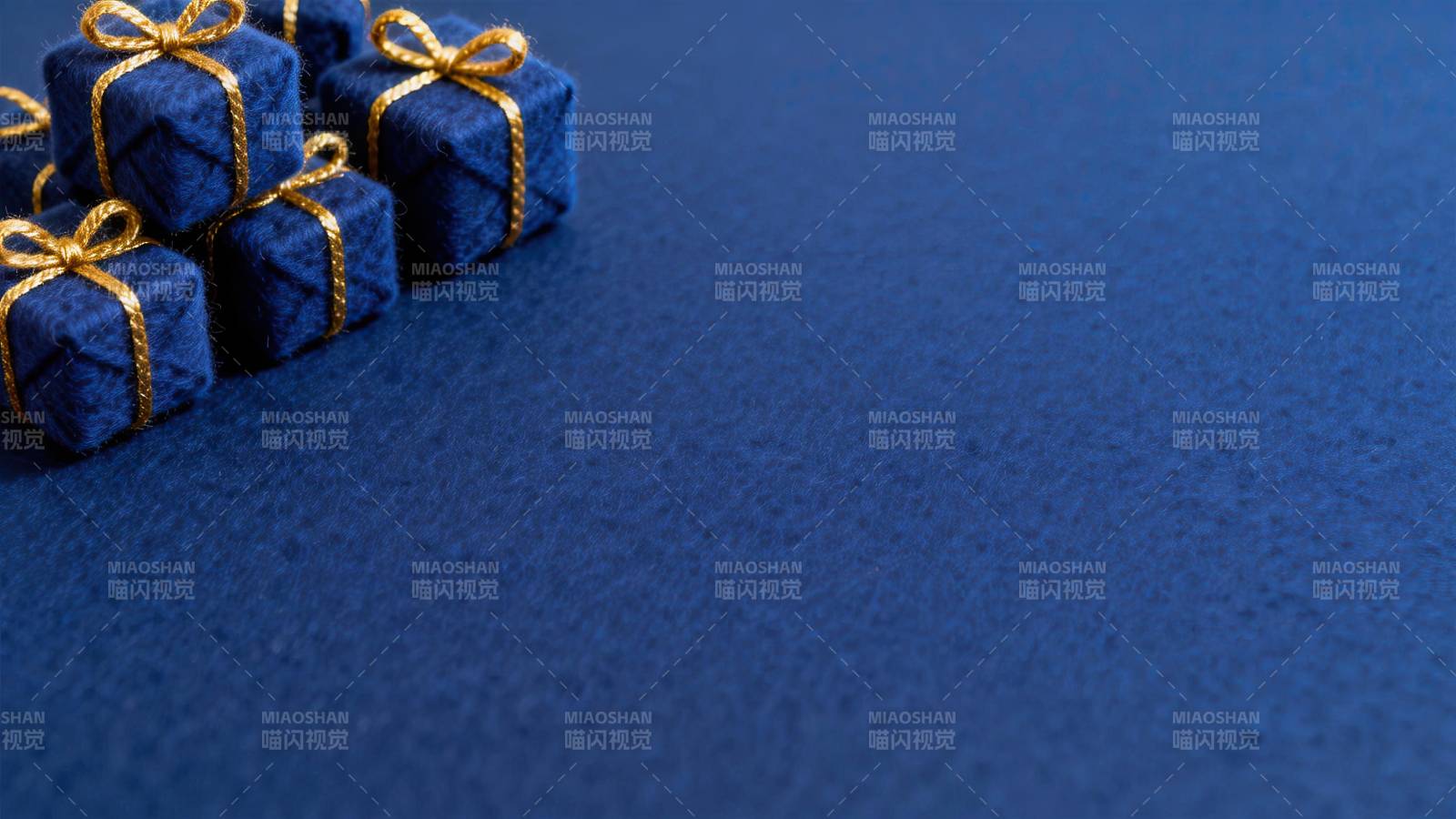 蓝色背景上的金色丝带礼盒图片
