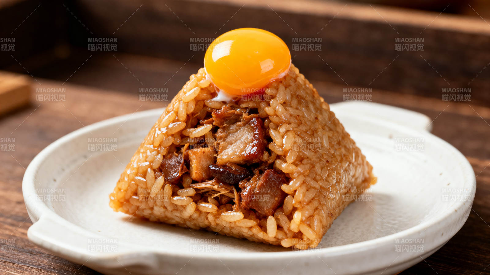 顶部流心蛋黄的肉粽图片