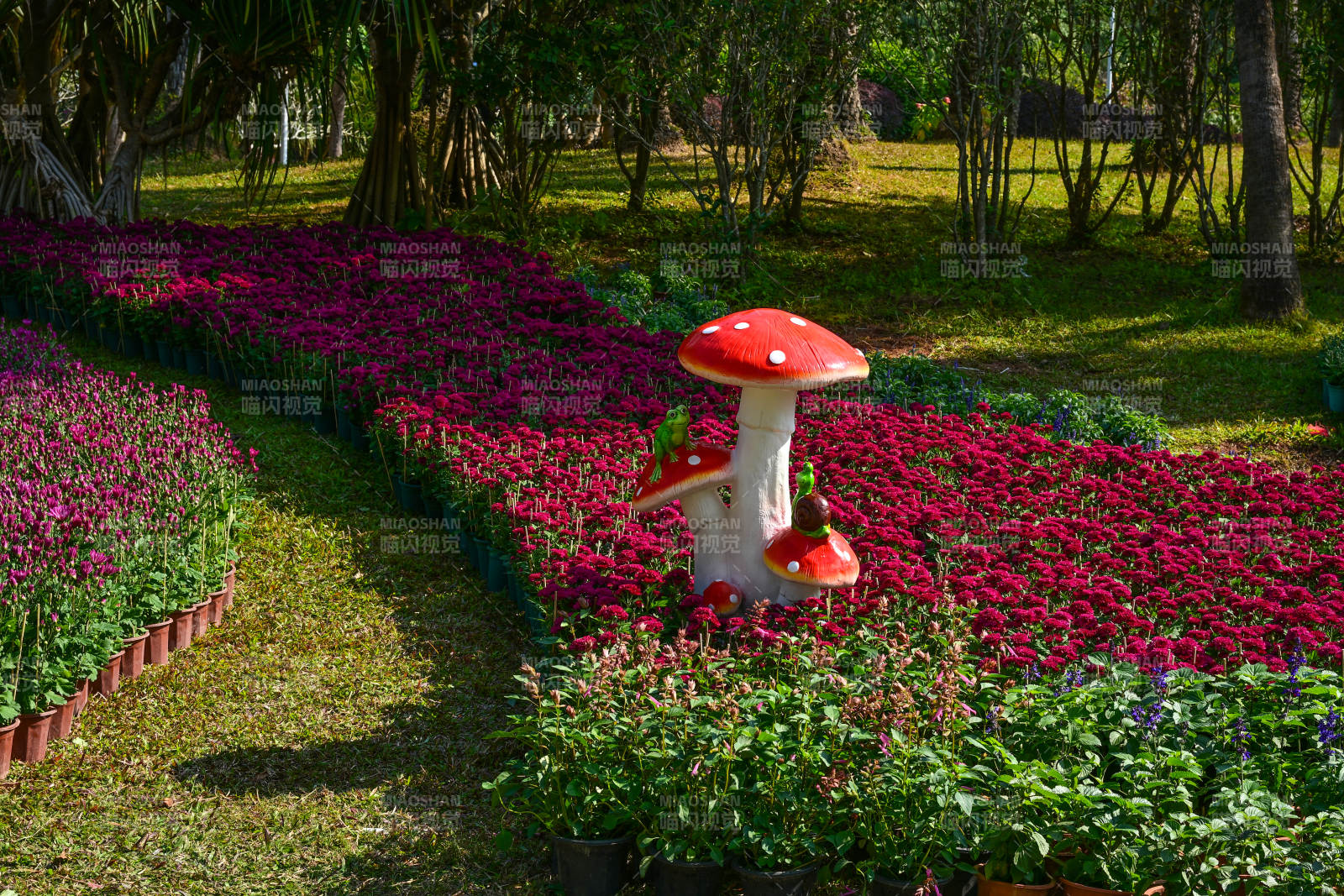 花海中的红色蘑菇雕塑造型图片