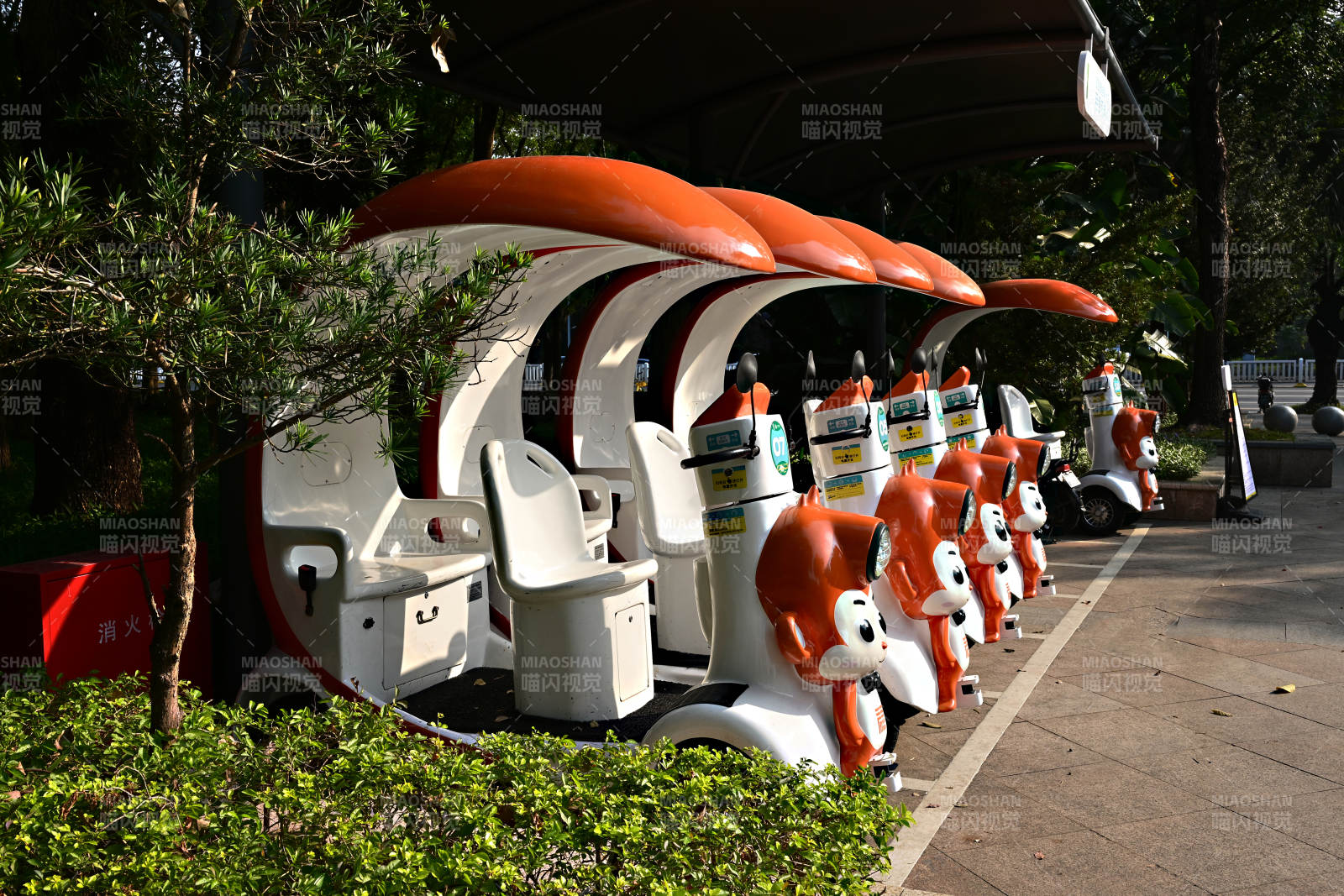 阳光下景区整齐排列的卡通造型观光游览车图片