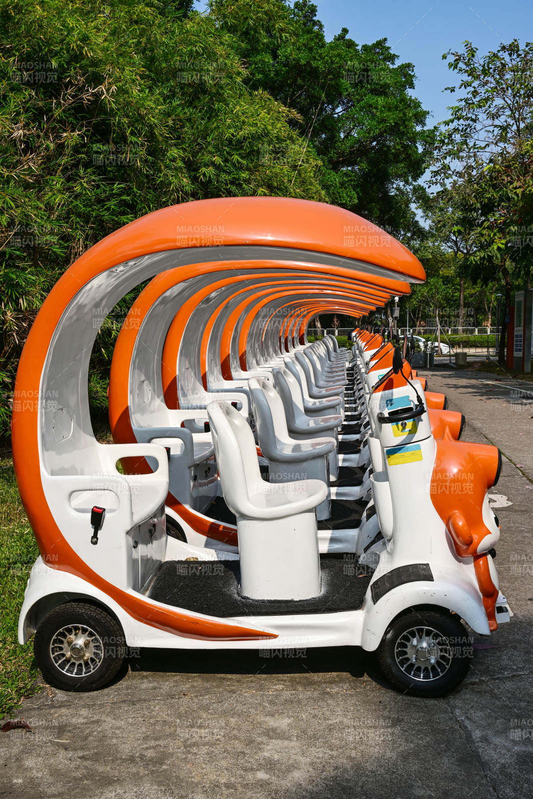 阳光下景区整齐排列的卡通造型观光游览车图片