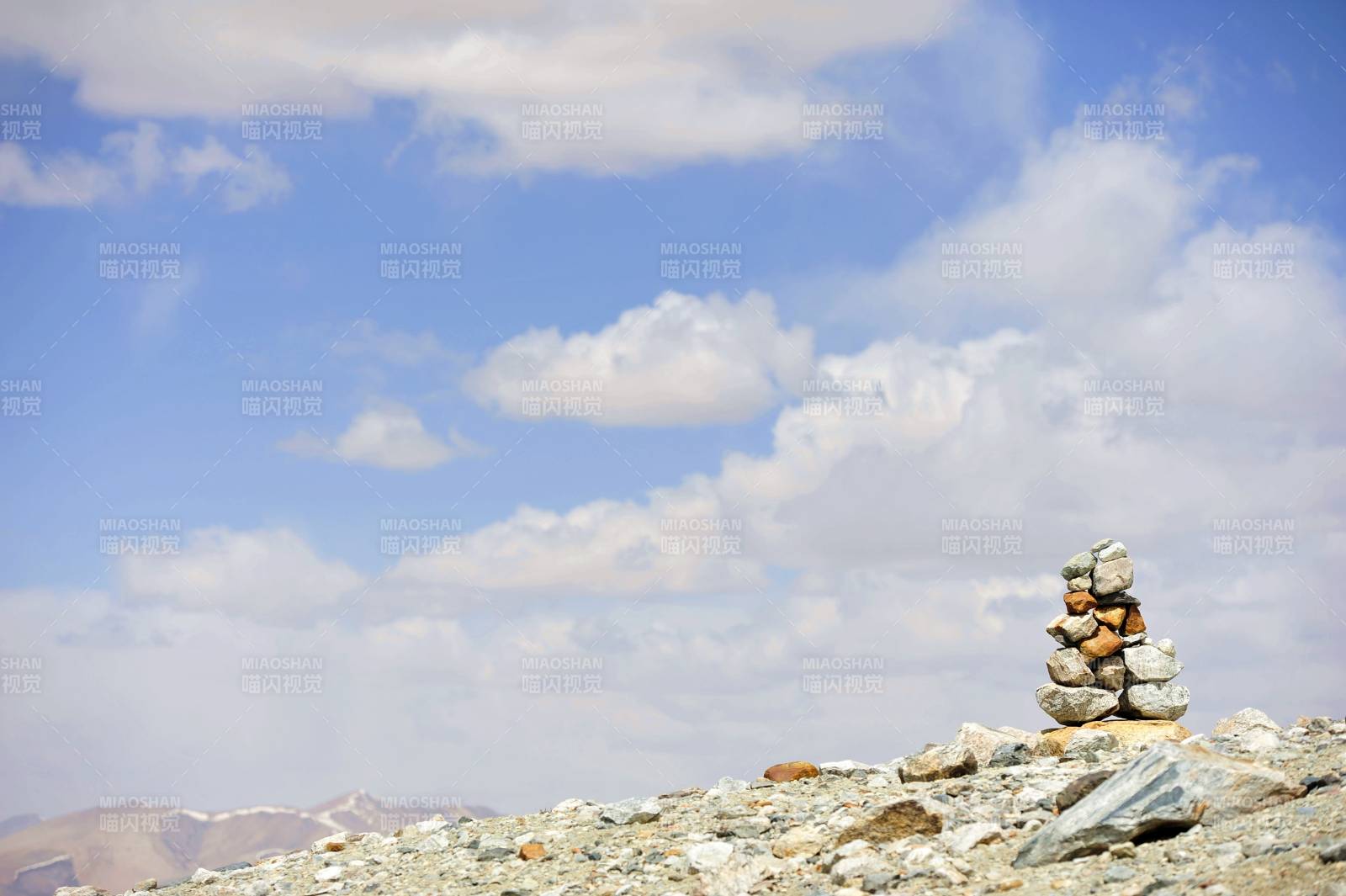 新疆山巅石堆映蓝天图片