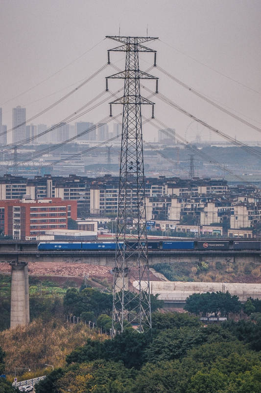 重庆城市高压塔下列车穿行图片