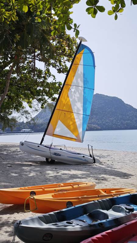 热带海岛沙滩上的帆船与皮划艇图片