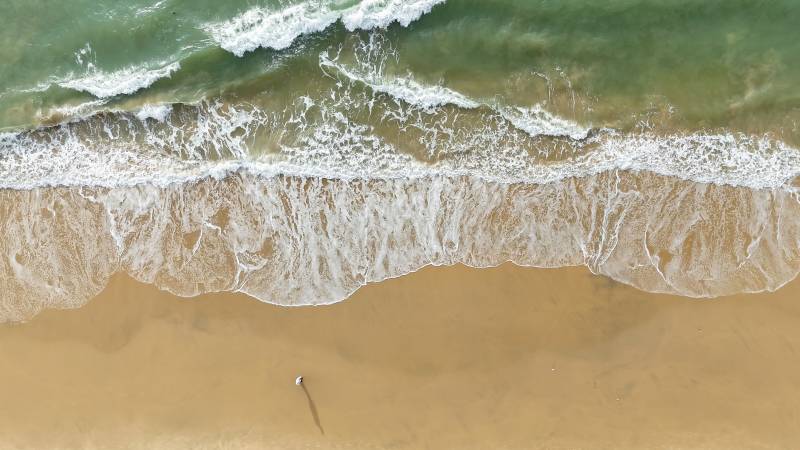 海南万宁航拍 海浪轻抚沙滩图片