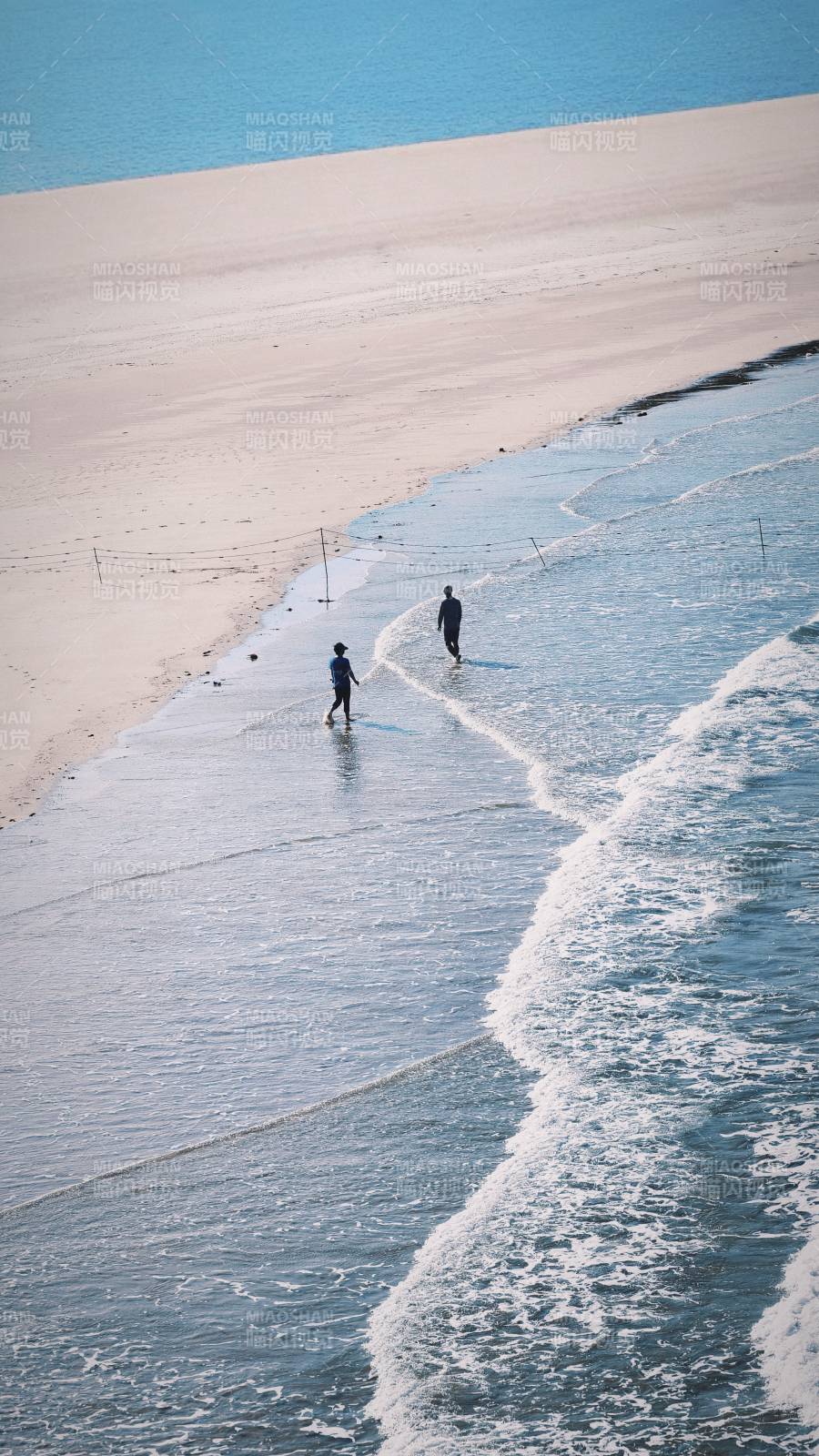 泉州海边散步的两人图片
