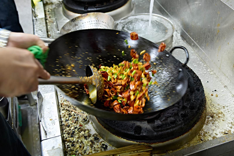 人与食物紧张忙碌的中餐厨房炒制辣子鸡丁图片