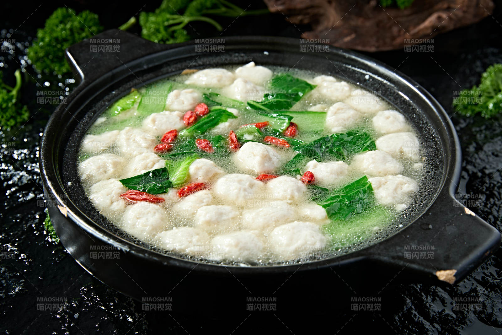 黑色砂锅炖煮的枸杞浓汤手打鱼丸图片