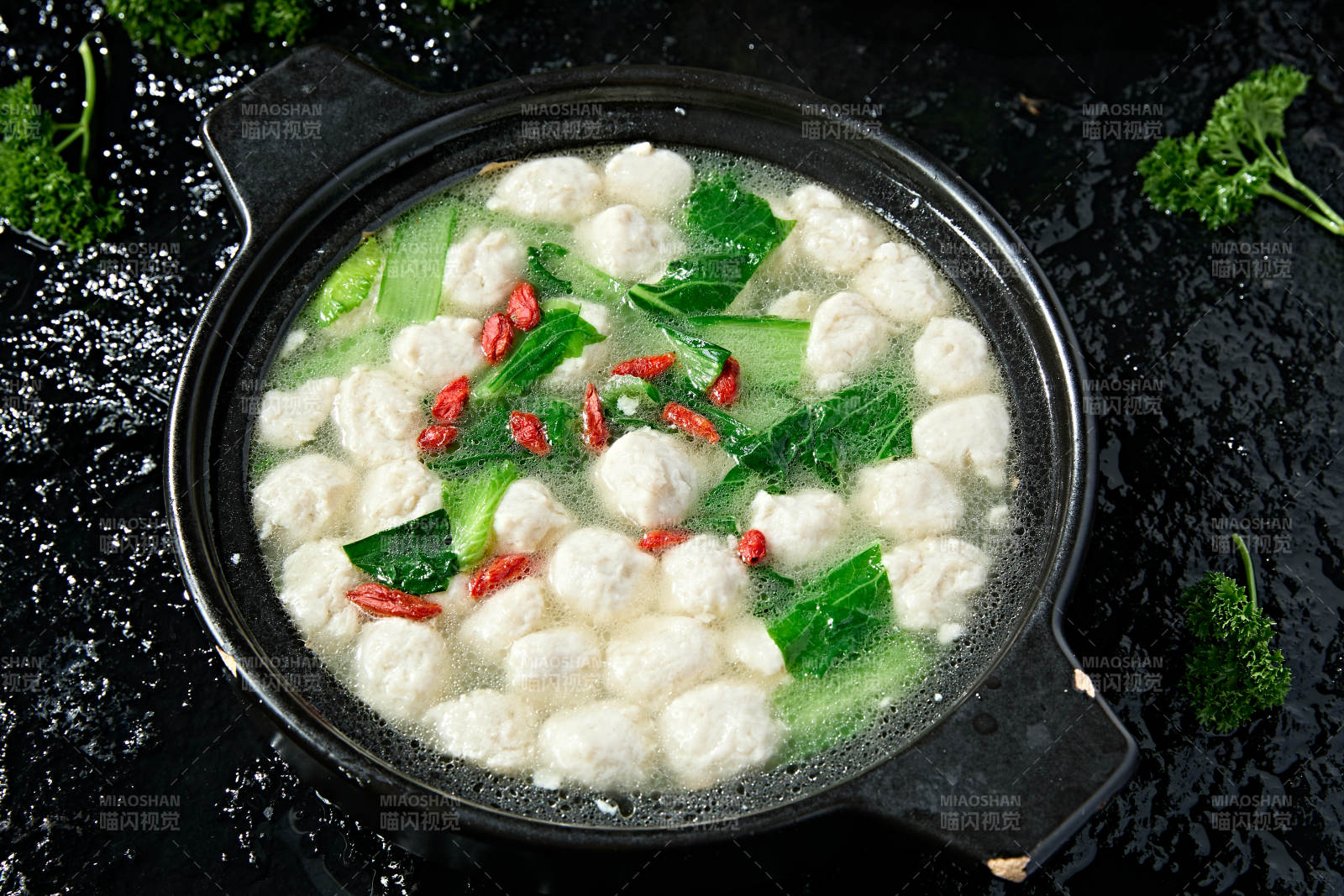 黑色砂锅炖煮的枸杞浓汤手打鱼丸图片