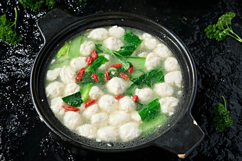 黑色砂锅炖煮的枸杞浓汤手打鱼丸图片