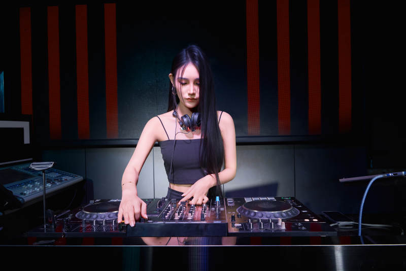 穿着性感黑色吊带裙的女DJ在打碟图片