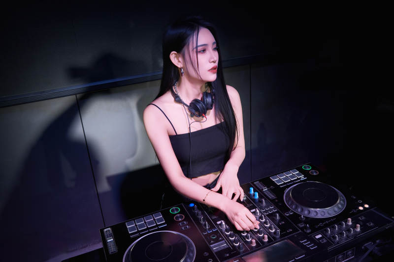 穿着性感黑色吊带裙的女DJ在打碟图片