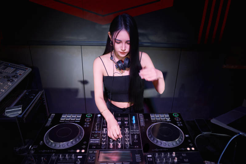 穿着性感黑色吊带裙的女DJ在打碟图片