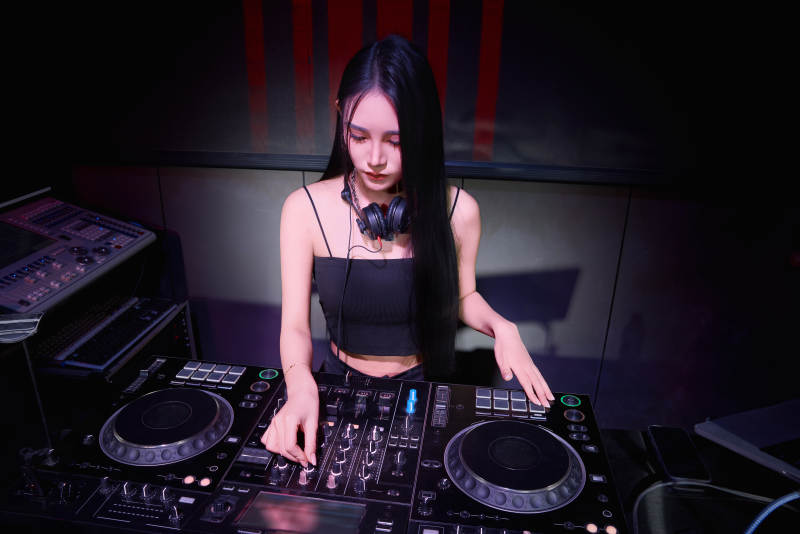 穿着性感黑色吊带裙的女DJ在打碟图片