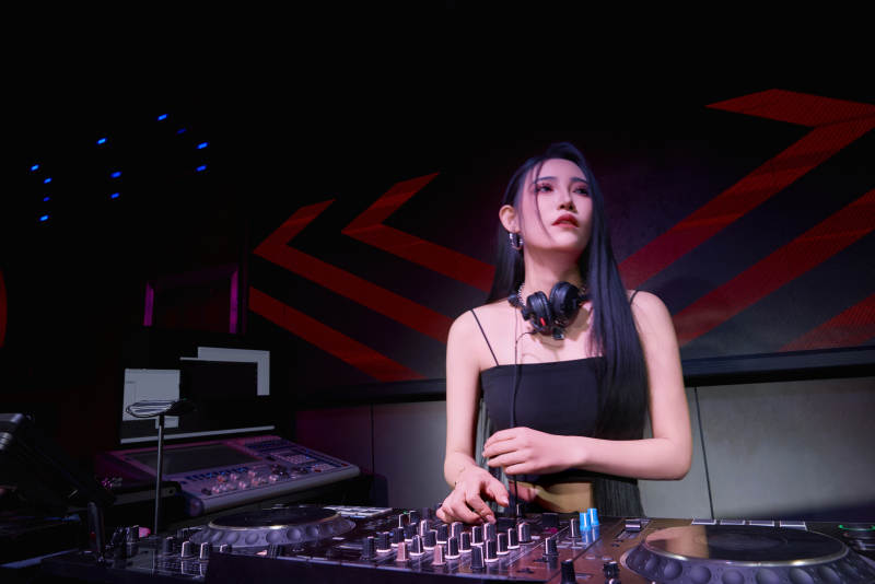 穿着性感黑色吊带裙的女DJ在打碟图片