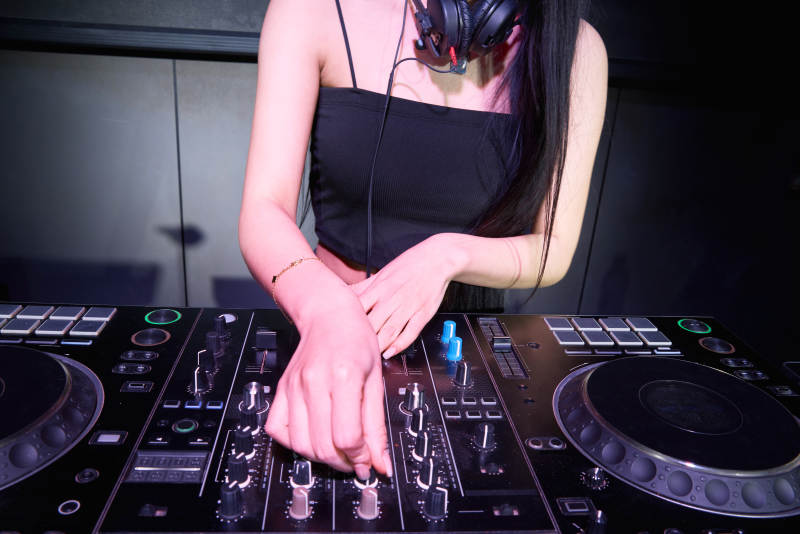 穿着性感黑色吊带裙的女DJ在打碟图片