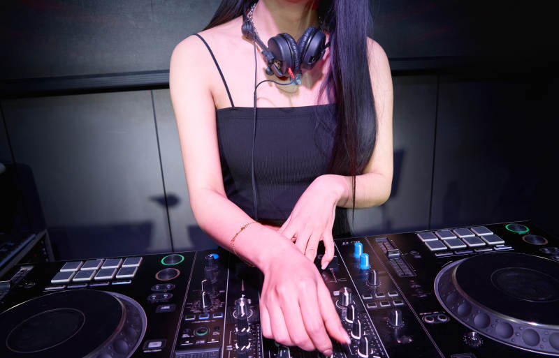 穿着性感黑色吊带裙的女DJ在打碟图片