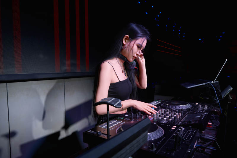 穿着性感黑色吊带裙的女DJ在打碟图片