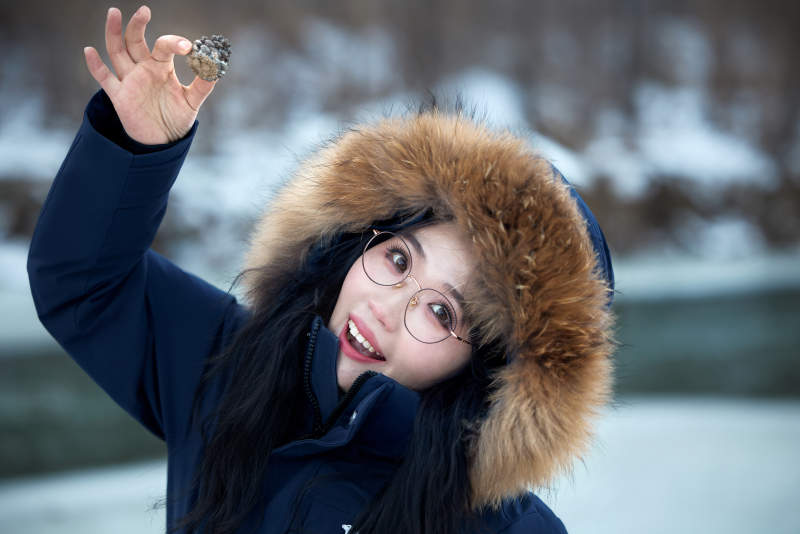 在野外雪地欣赏雪景游玩拍照的亚洲女性图片