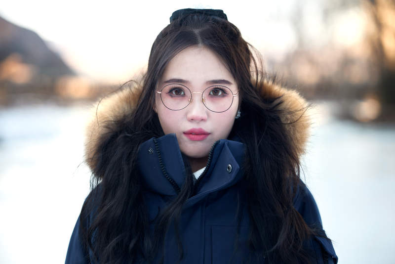 在野外雪地欣赏雪景游玩拍照的亚洲女性图片