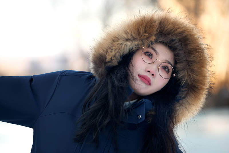 在野外雪地欣赏雪景游玩拍照的亚洲女性图片