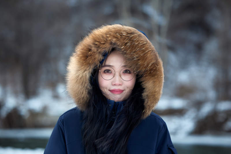 在野外雪地欣赏雪景游玩拍照的亚洲女性图片