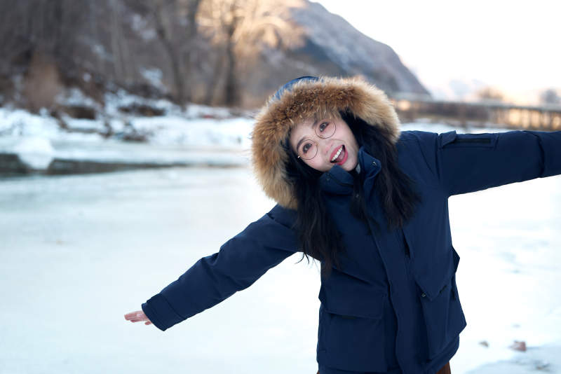 在野外雪地欣赏雪景游玩拍照的亚洲女性图片