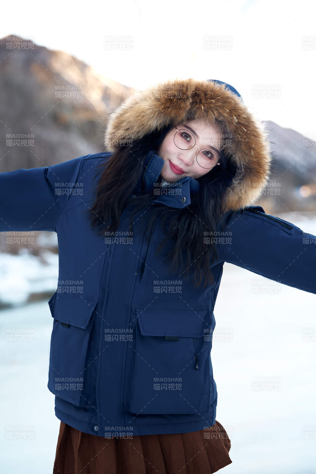在野外雪地欣赏雪景游玩拍照的亚洲女性图片