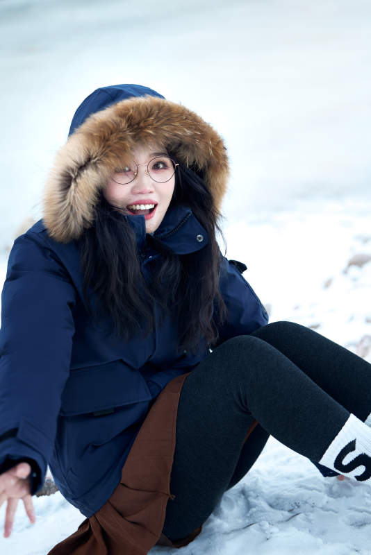 在野外雪地欣赏雪景游玩拍照的亚洲女性图片