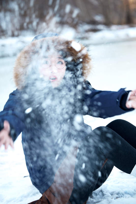 在野外雪地欣赏雪景游玩拍照的亚洲女性图片